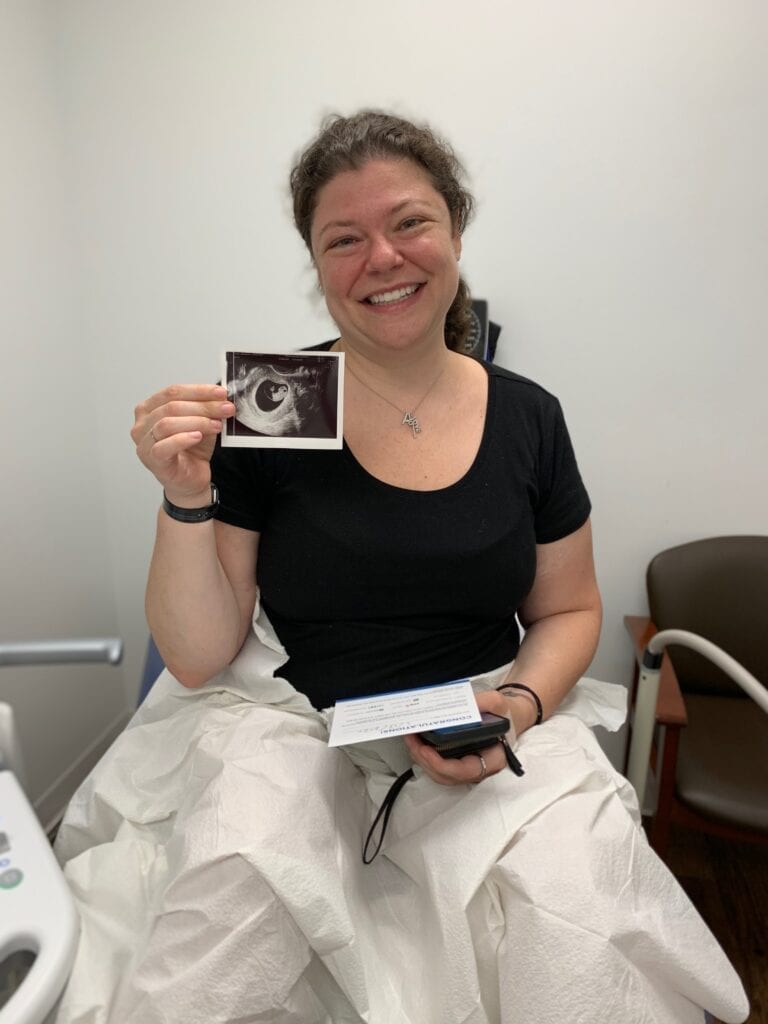 Alexandra Fisher holding a sonogram of her baby